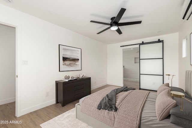 1338 E Granada Rd, Phoenix, AZ 85006 - bedroom with a wall unit AC, a barn door, light wood finished floors, and a ceiling fan