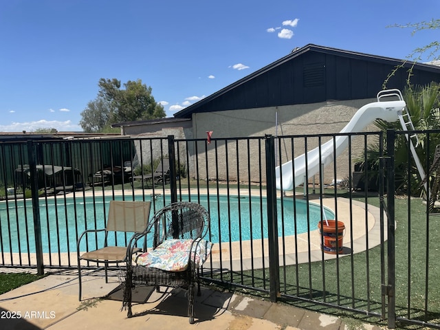 view of swimming pool with fence, a water slide, a patio area, and a fenced in pool
