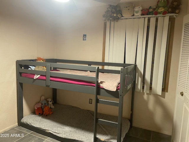 tiled bedroom featuring baseboards