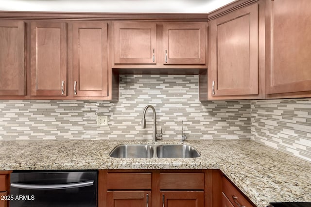 kitchen with tasteful backsplash, light stone countertops, black dishwasher, and sink