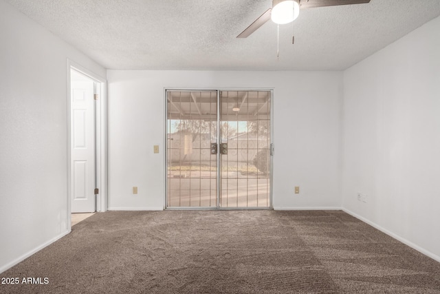 empty room featuring ceiling fan, carpet, and a textured ceiling