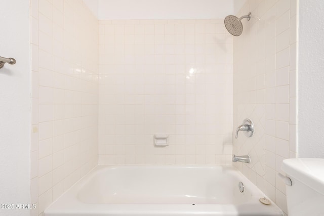 bathroom with tiled shower / bath and toilet