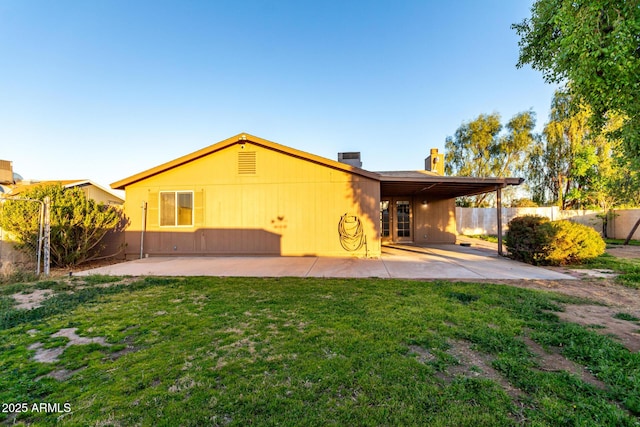 rear view of house with a yard and a patio area