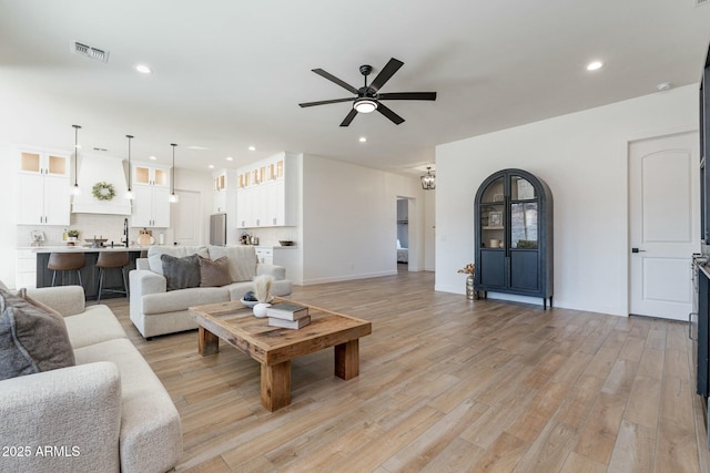 living room with ceiling fan and light wood-type flooring