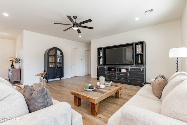 living room featuring wood-type flooring and ceiling fan