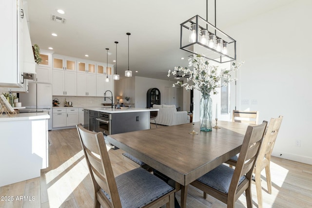 dining space with sink and light hardwood / wood-style flooring