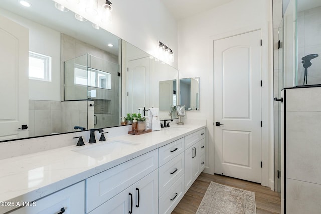 bathroom with vanity, hardwood / wood-style floors, and a shower with door