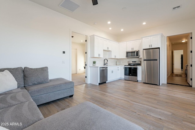 living room with sink and light hardwood / wood-style flooring