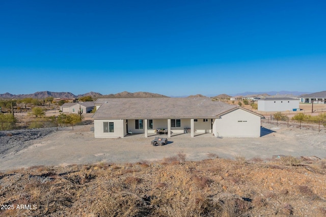 back of house with a mountain view and a patio