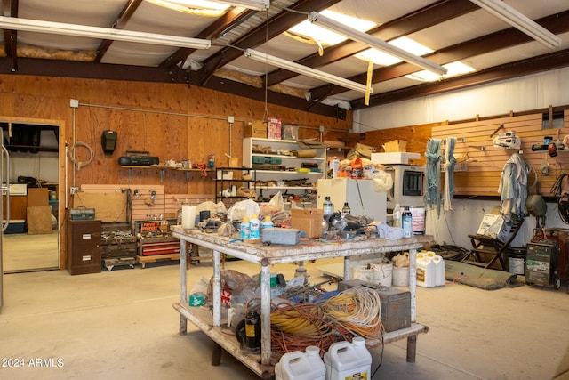 garage featuring a workshop area and wood walls
