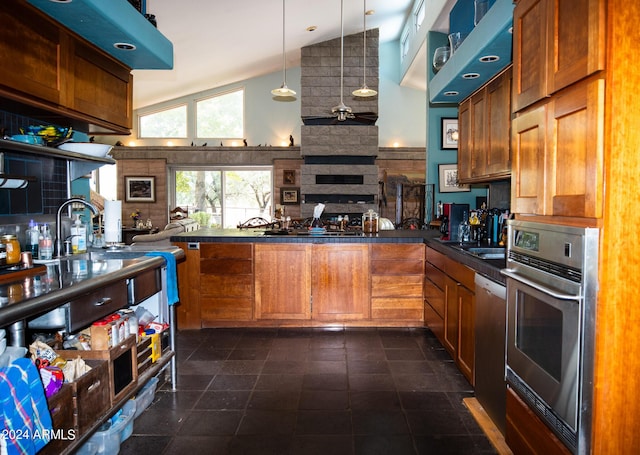 kitchen with oven, dark countertops, open floor plan, a large fireplace, and brown cabinetry