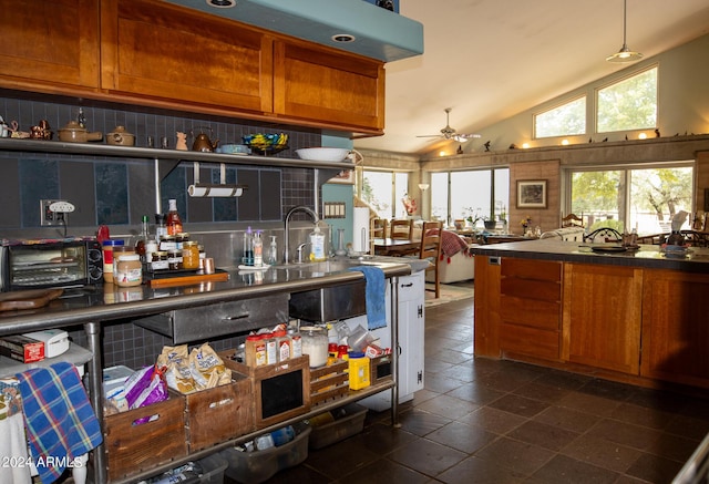 kitchen featuring brown cabinets, a sink, a toaster, lofted ceiling, and ceiling fan
