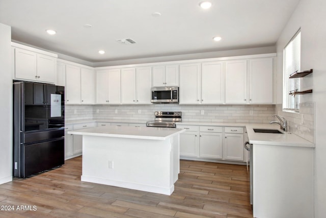 kitchen featuring sink, stainless steel appliances, backsplash, and white cabinets