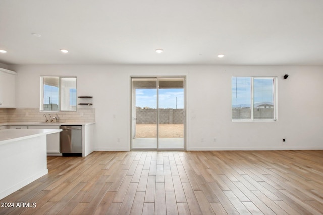 kitchen with dishwasher, white cabinets, and plenty of natural light