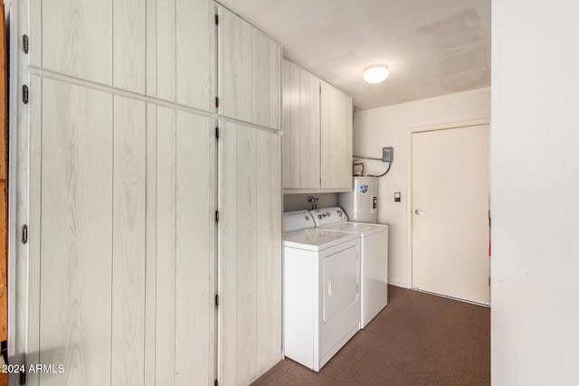 washroom featuring cabinets, electric water heater, dark carpet, and washing machine and clothes dryer