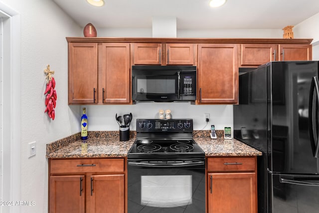 kitchen featuring dark stone counters and black appliances