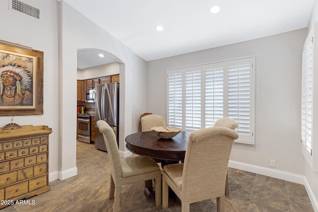 dining area with arched walkways, recessed lighting, visible vents, and baseboards