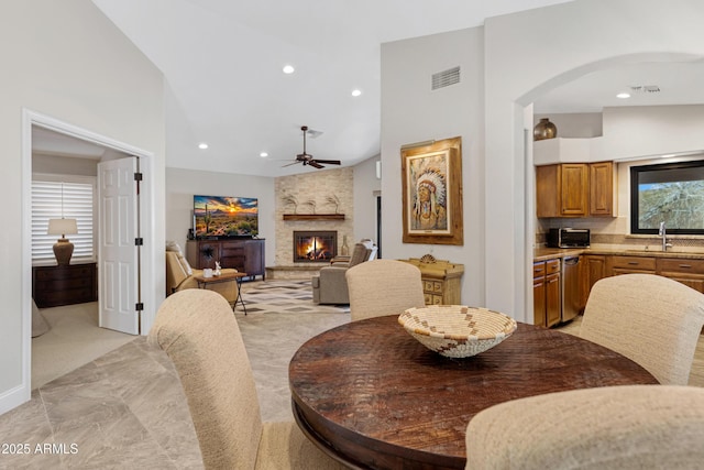 dining room featuring high vaulted ceiling, recessed lighting, visible vents, and a fireplace