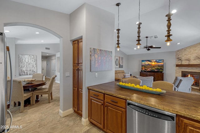 kitchen with visible vents, arched walkways, open floor plan, hanging light fixtures, and stainless steel appliances