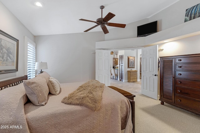 bedroom with lofted ceiling, a ceiling fan, and light colored carpet