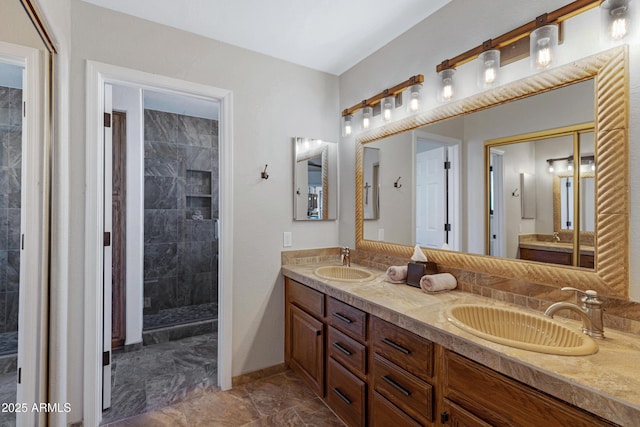 full bathroom with double vanity, marble finish floor, a shower stall, and a sink