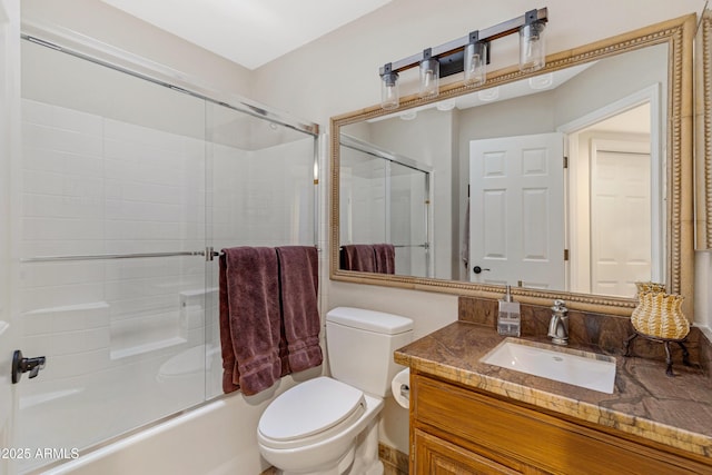 bathroom featuring enclosed tub / shower combo, vanity, and toilet