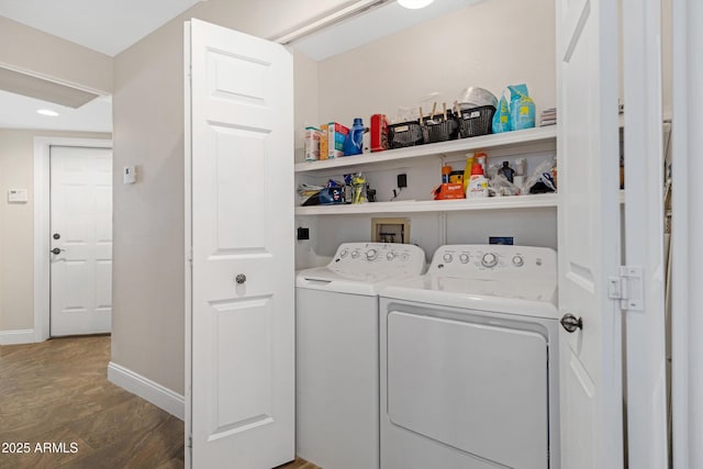 clothes washing area featuring laundry area, baseboards, dark wood-style flooring, and washer and dryer