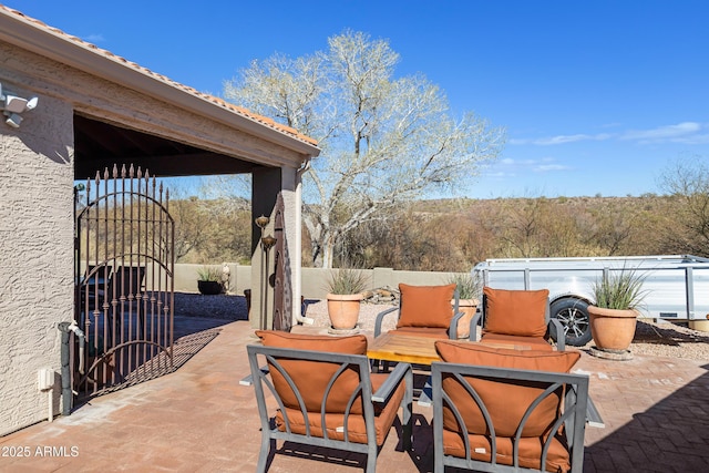 view of patio / terrace with outdoor dining space, fence, and a gate