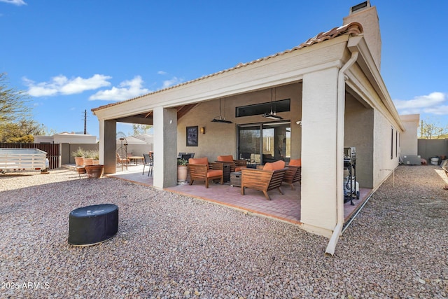 back of property with a patio, ceiling fan, fence, outdoor lounge area, and stucco siding