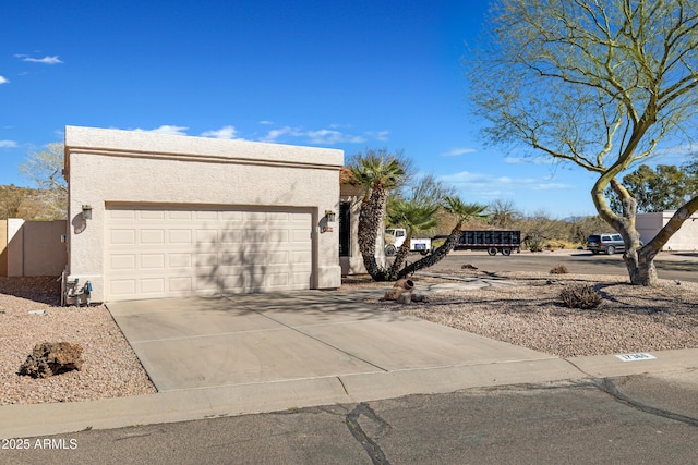 view of side of home featuring driveway, an attached garage, and stucco siding