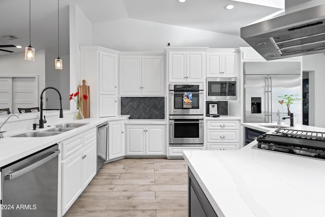 kitchen with lofted ceiling, built in appliances, decorative backsplash, and white cabinets