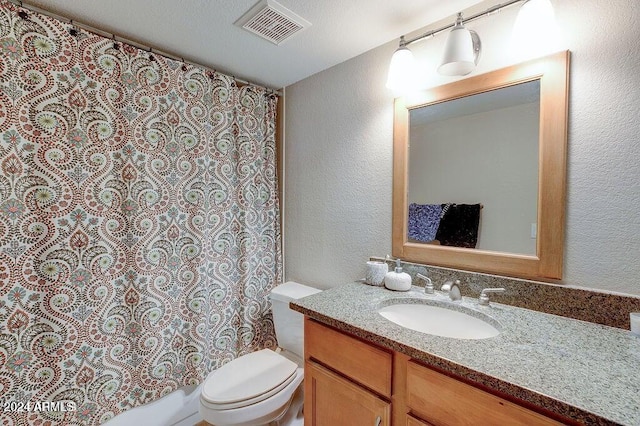 bathroom featuring toilet, vanity, visible vents, and a textured wall