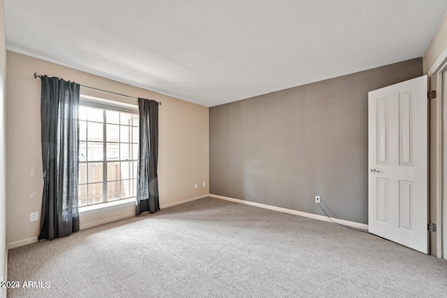 spare room with carpet and baseboards