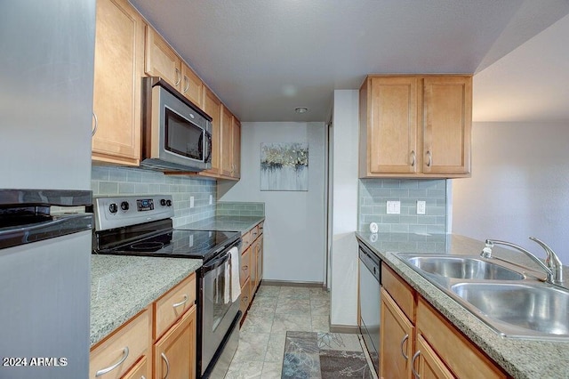 kitchen with appliances with stainless steel finishes, backsplash, a sink, and baseboards