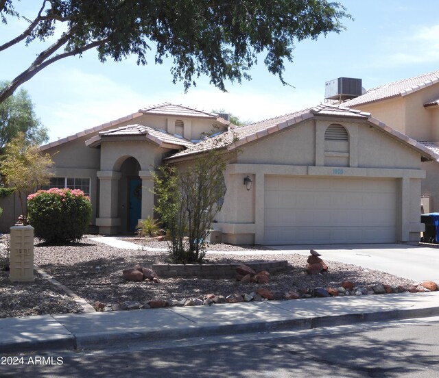 view of front of house featuring a garage and central AC