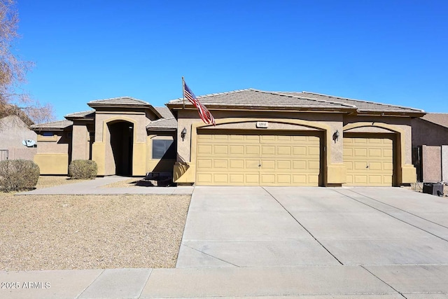 prairie-style home with driveway, an attached garage, a tile roof, and stucco siding