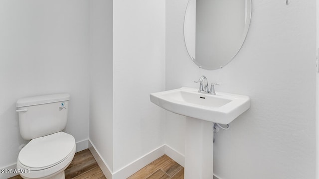 bathroom featuring wood finished floors, toilet, and baseboards