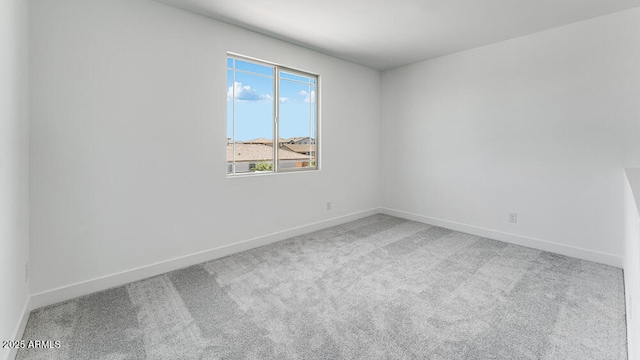 unfurnished room featuring carpet floors and baseboards