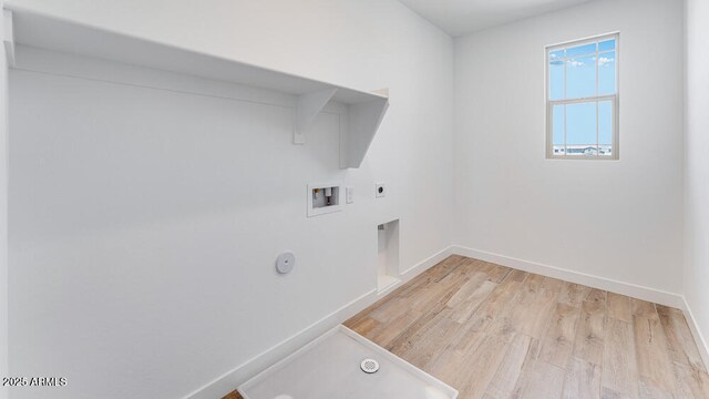 clothes washing area featuring hookup for a gas dryer, washer hookup, light wood-style floors, baseboards, and hookup for an electric dryer