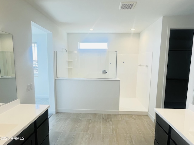 full bath with walk in shower, vanity, baseboards, and recessed lighting