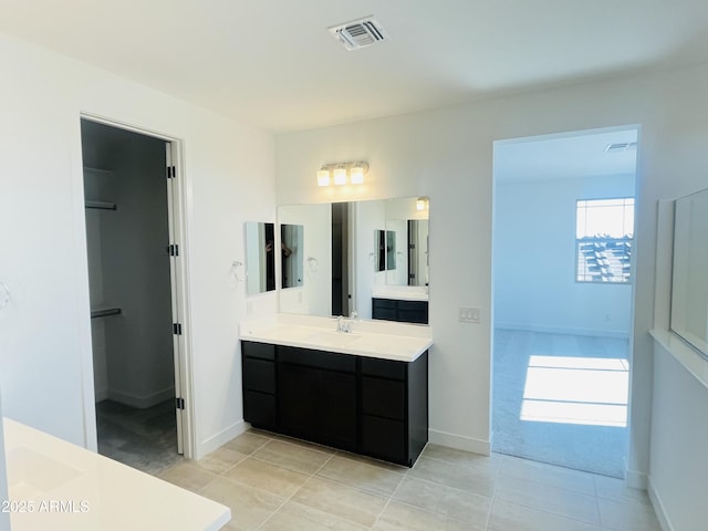 full bath with vanity, tile patterned flooring, and baseboards