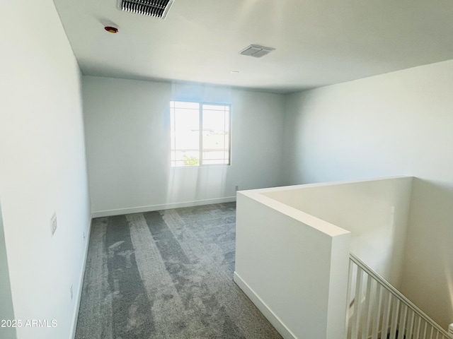 empty room featuring carpet and baseboards