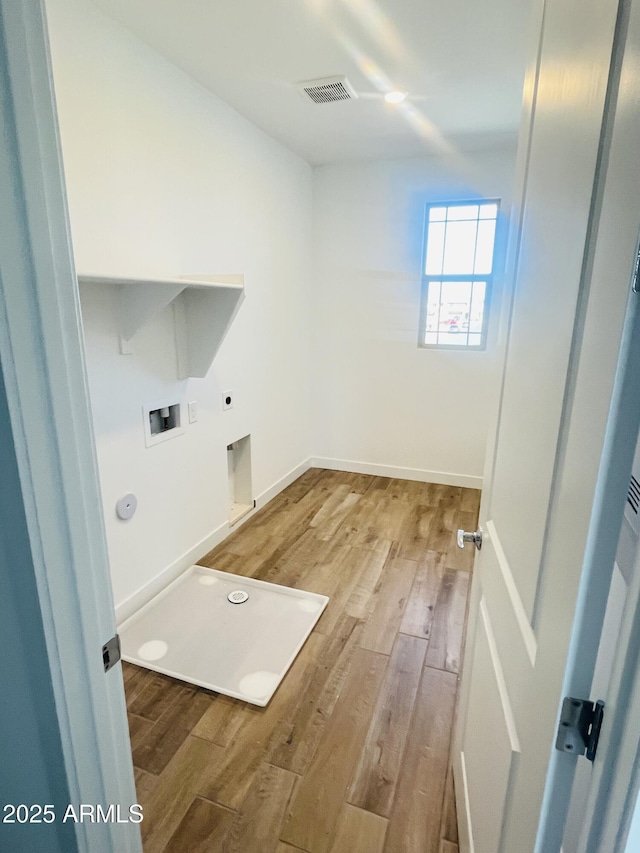 laundry area with electric dryer hookup, wood finished floors, hookup for a washing machine, and baseboards