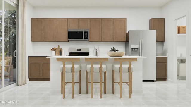 kitchen featuring stainless steel microwave, refrigerator with ice dispenser, range, a kitchen island, and light countertops