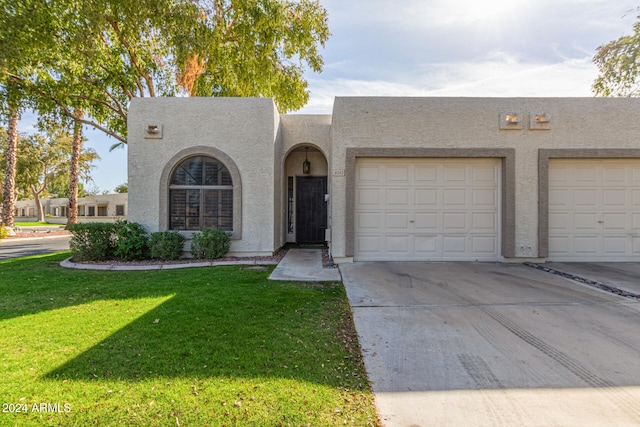 southwest-style home featuring a garage and a front yard