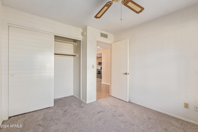 unfurnished bedroom featuring carpet floors, a closet, and ceiling fan