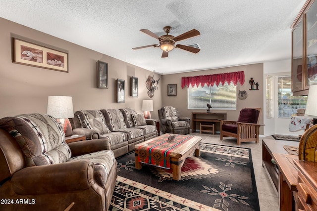 living room featuring ceiling fan and a textured ceiling