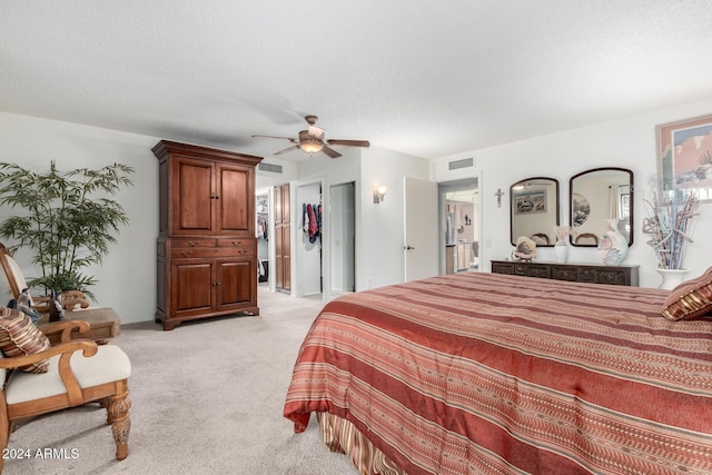 carpeted bedroom with ceiling fan, a textured ceiling, and a closet