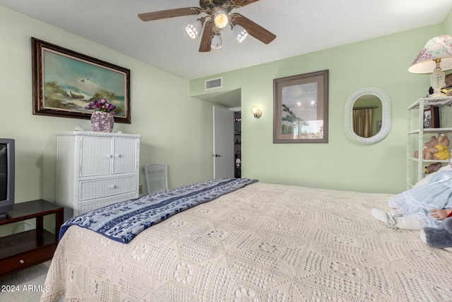 carpeted bedroom with a textured ceiling and ceiling fan