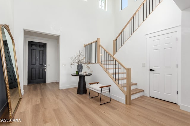 foyer with a towering ceiling and light hardwood / wood-style floors